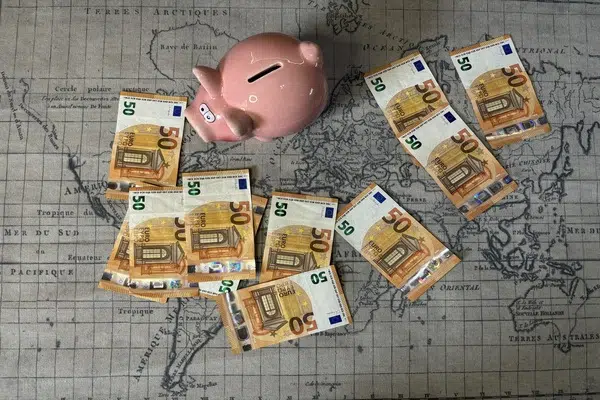 spaarvarken op wereldkaart met eurobiljetten