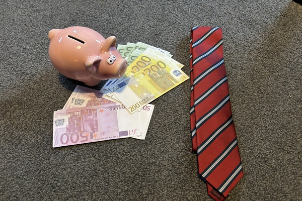 Spaarvarken met geld en een stropdas